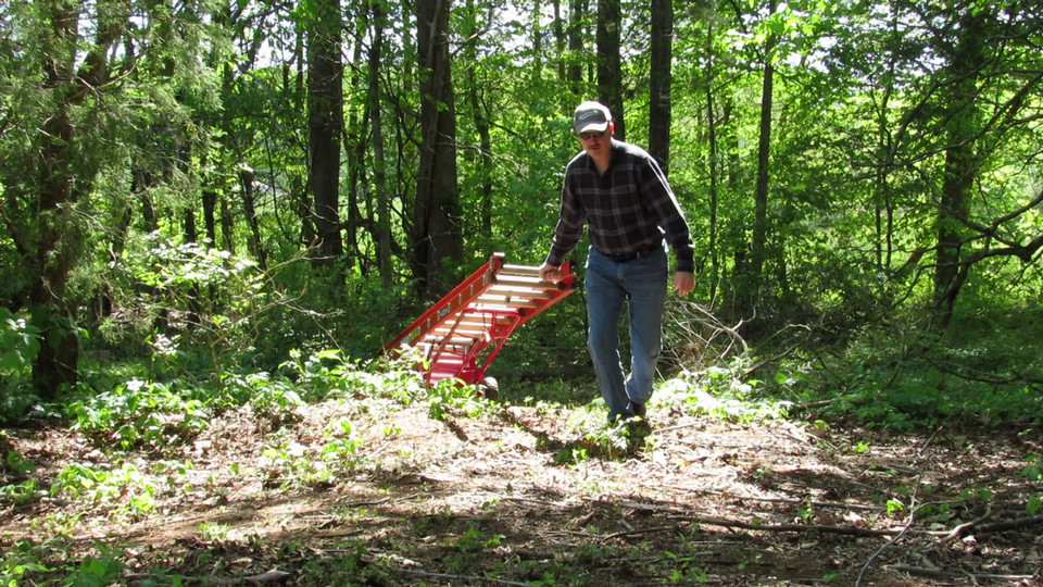 Ladder Mover™ carrying a ladder over rough terrain.